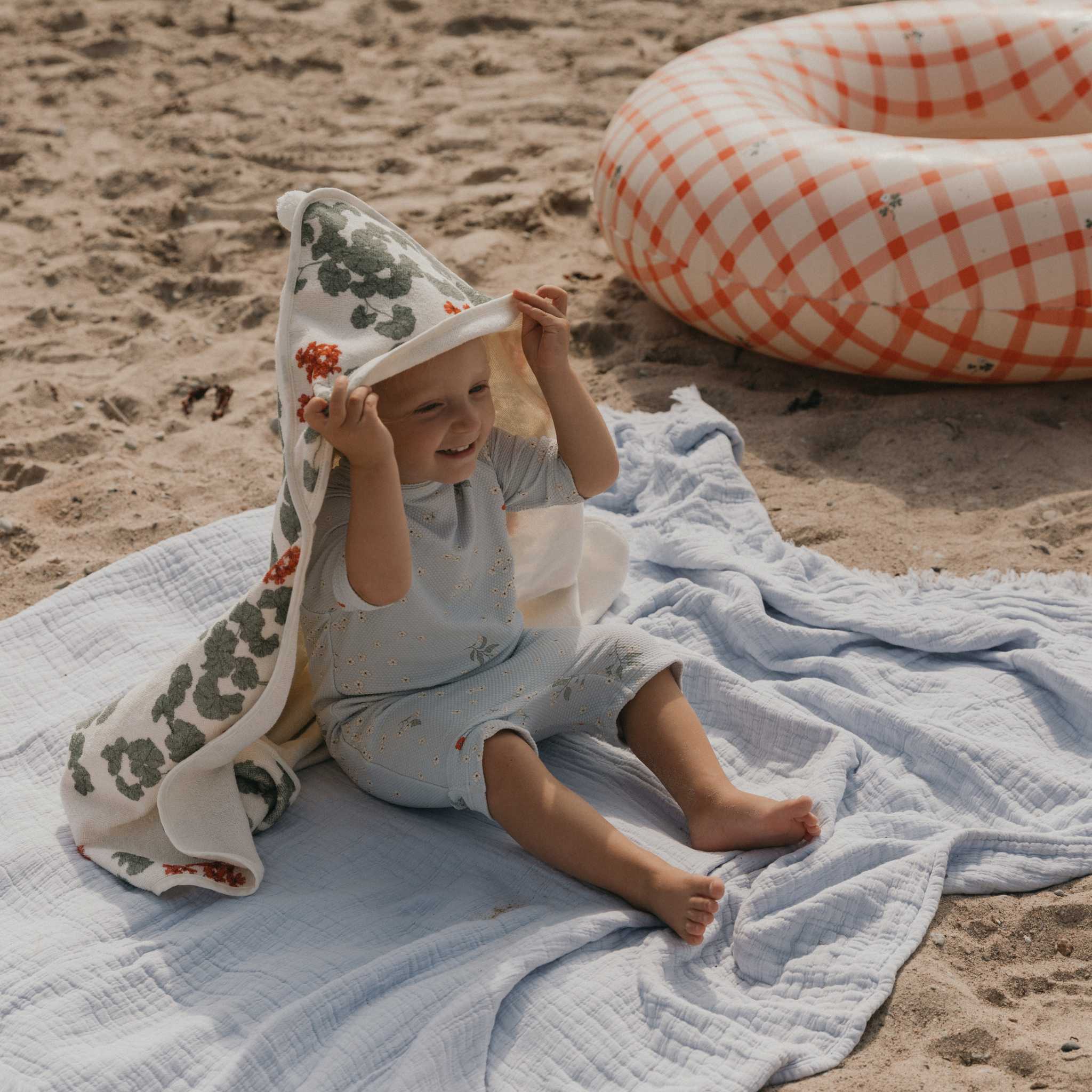 Baby Sitting On Garbo & Friends Cotton Blanket Blue On Beach