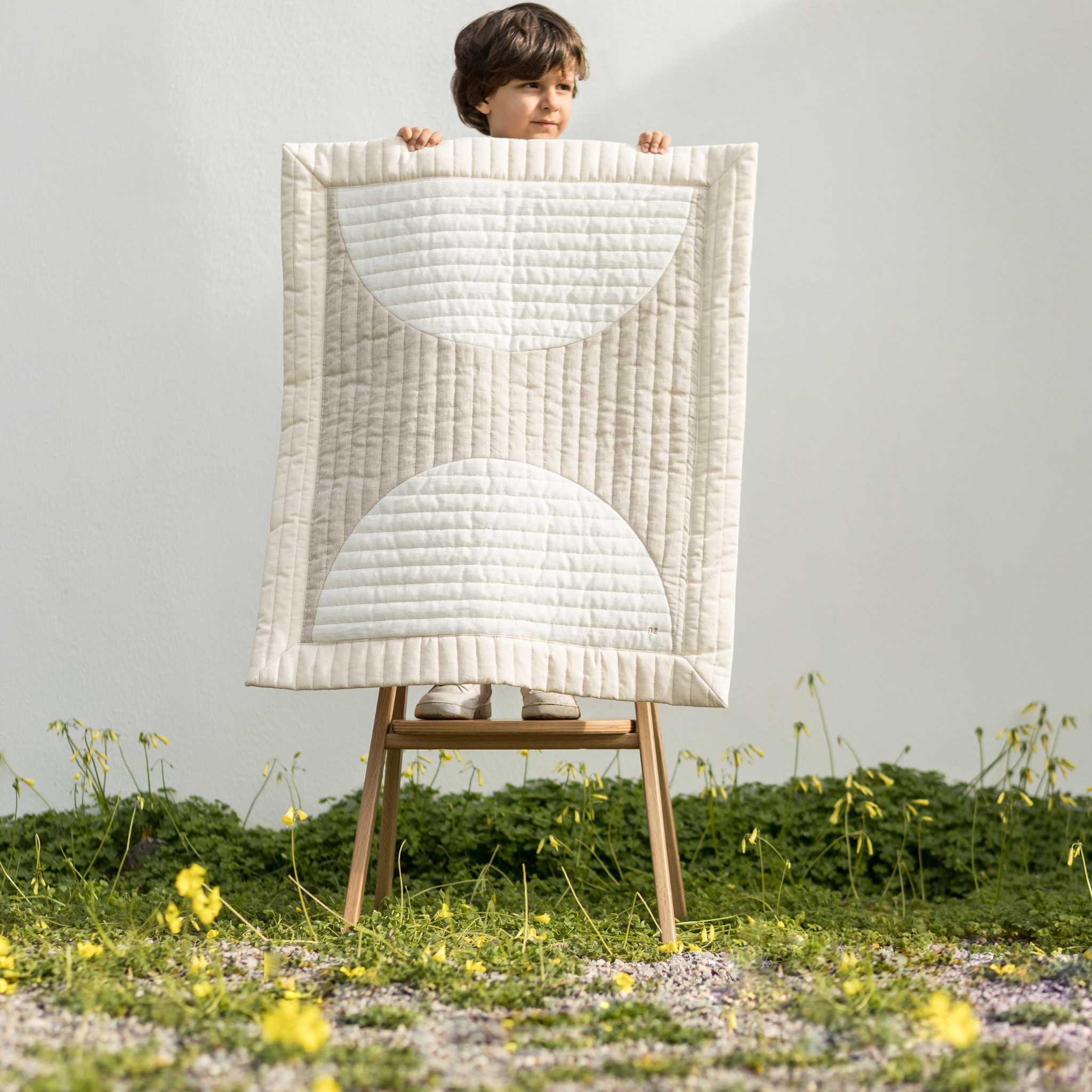 Boy on Stool Holding Nododinoz Lin Francais Moon Quilted Blanket