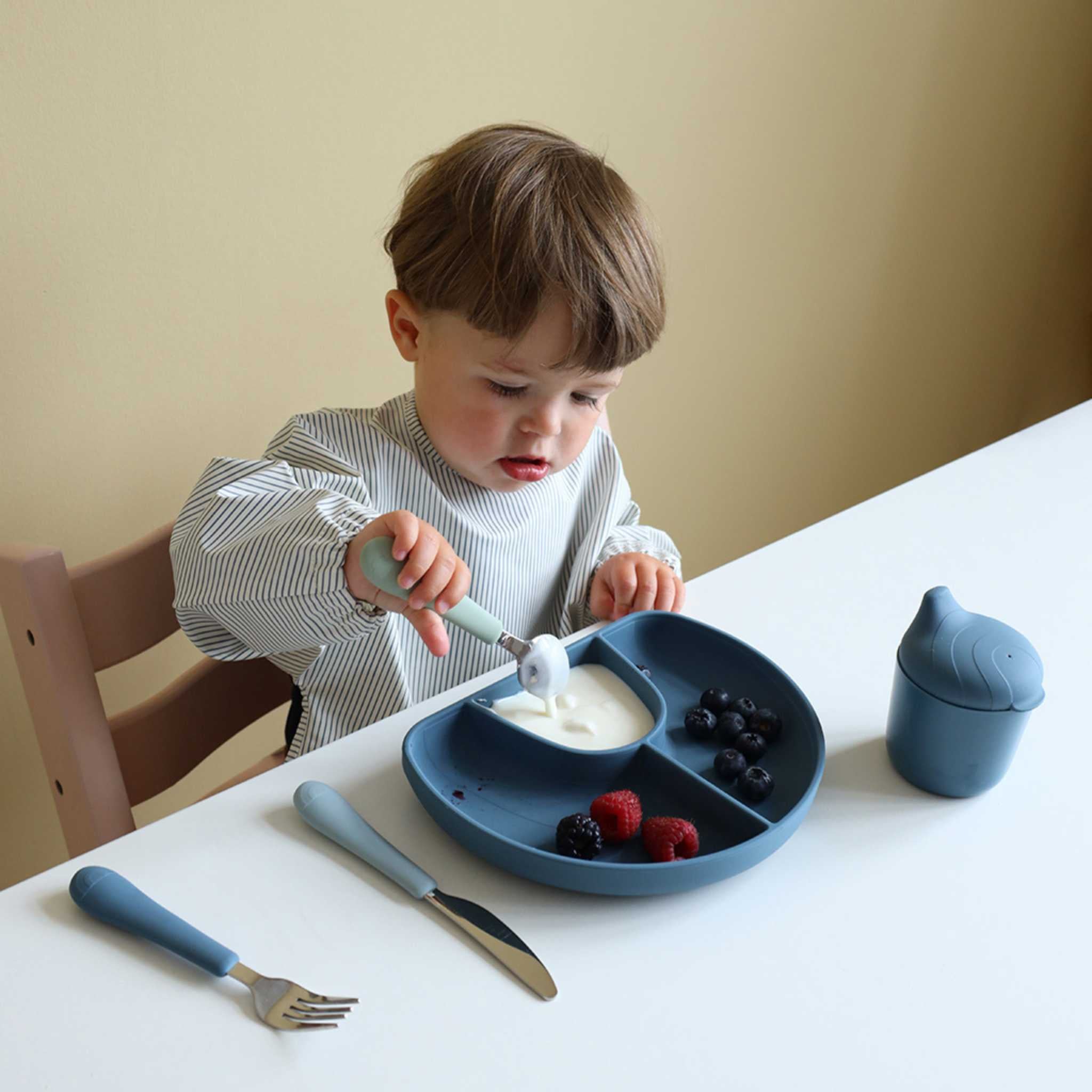 Cam Cam Copenhagen Sleeved Bib in Classic Blue Stripes Boy Eating