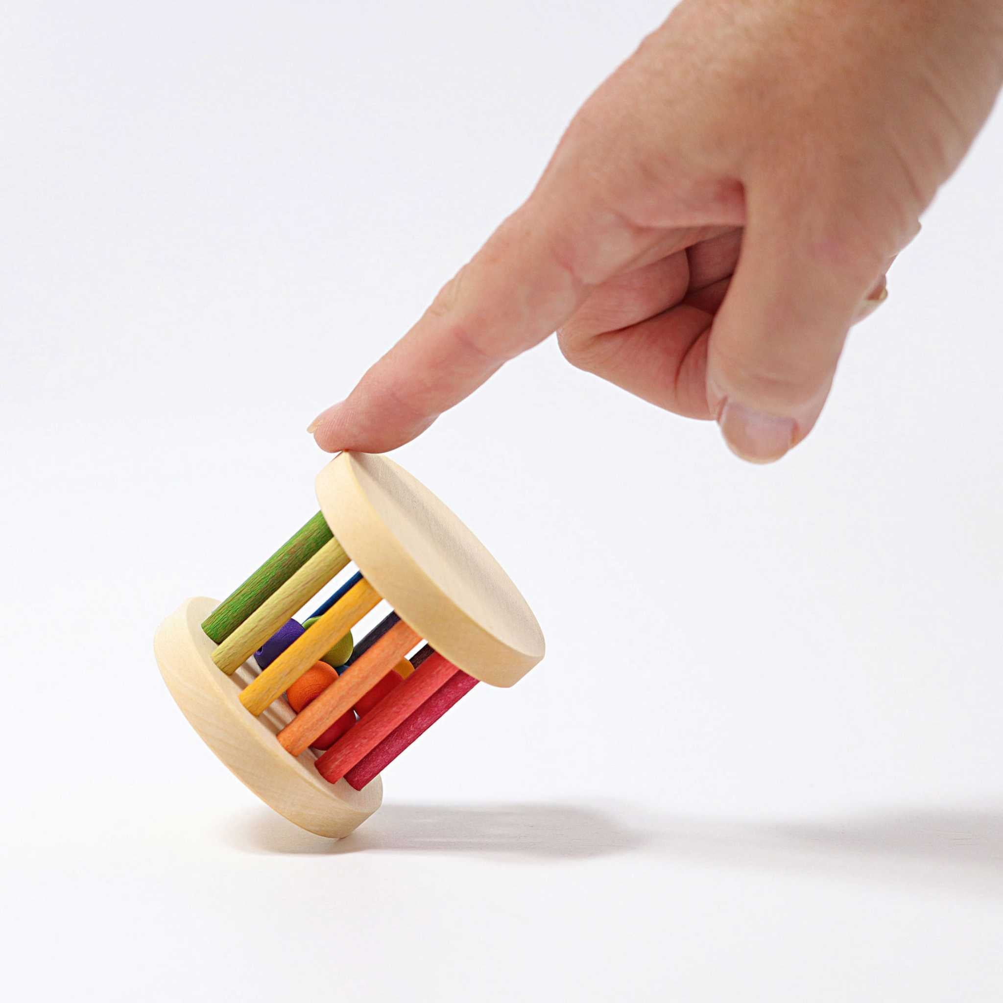 Hand Holding Grimm's Rainbow Mini Rolling Wheel Rattle