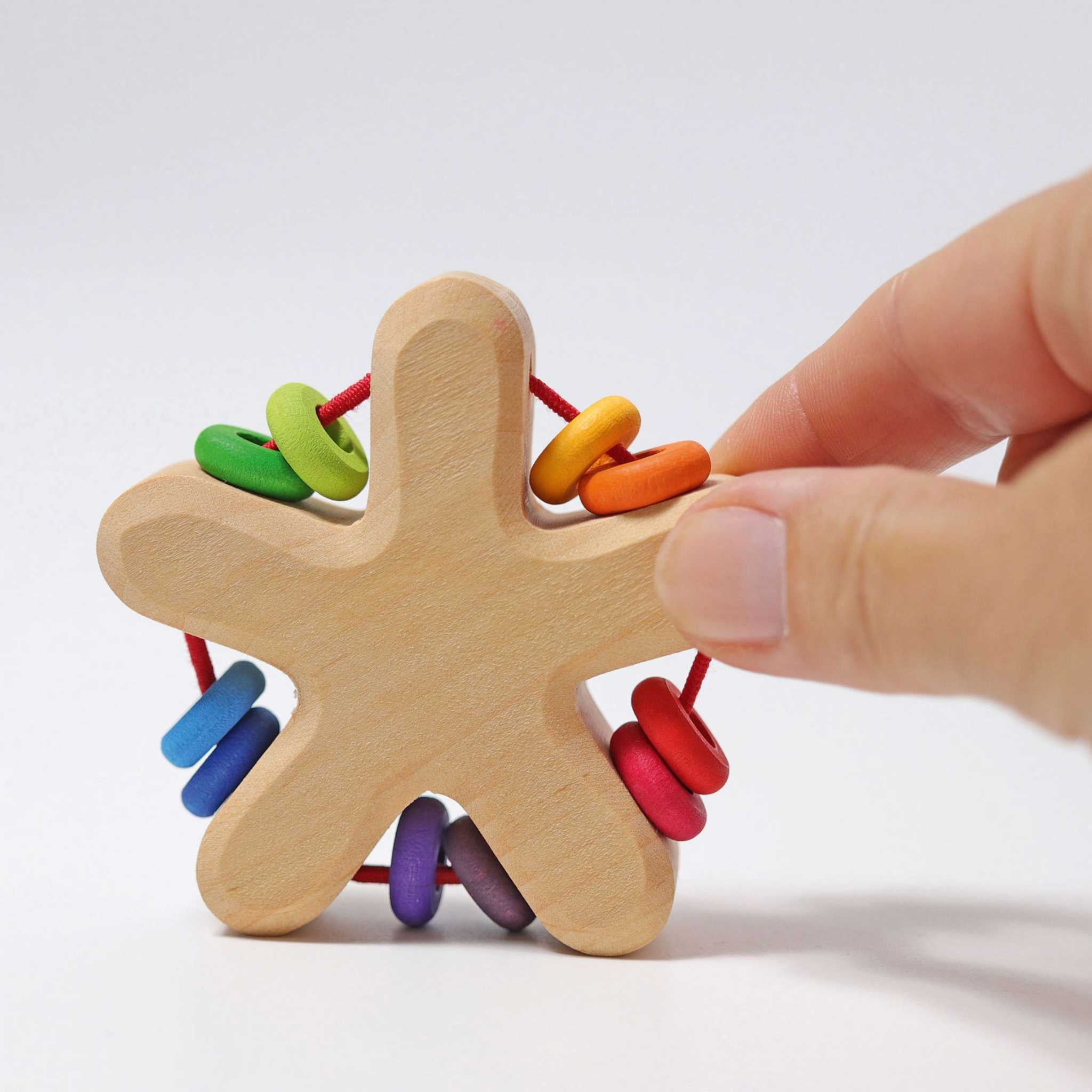 Hand Holding Grimm's Rainbow Star Rattle