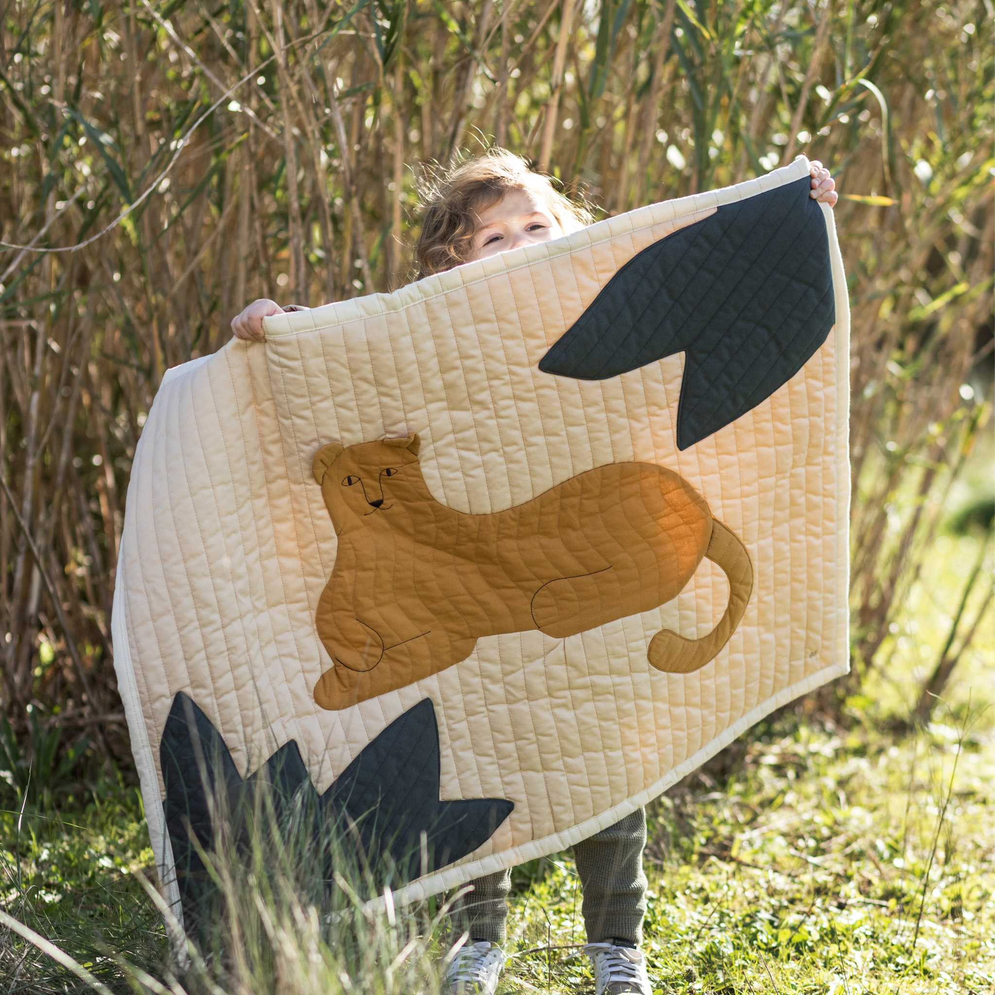 Little Boy Holding Nododinoz Leopard Quilted Blanket