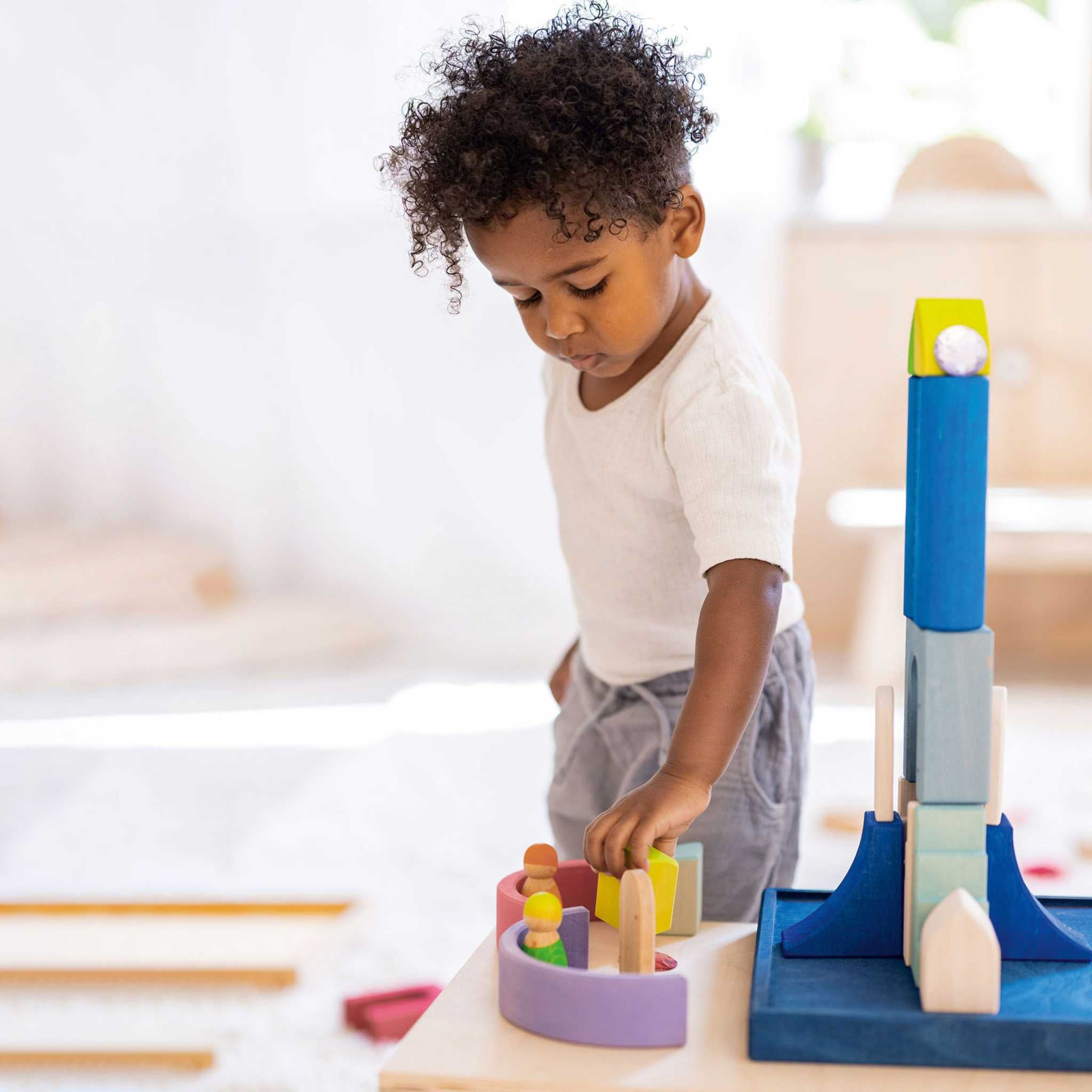 Little Boy Playing With Grimm's Polar Light Play Building World Set 