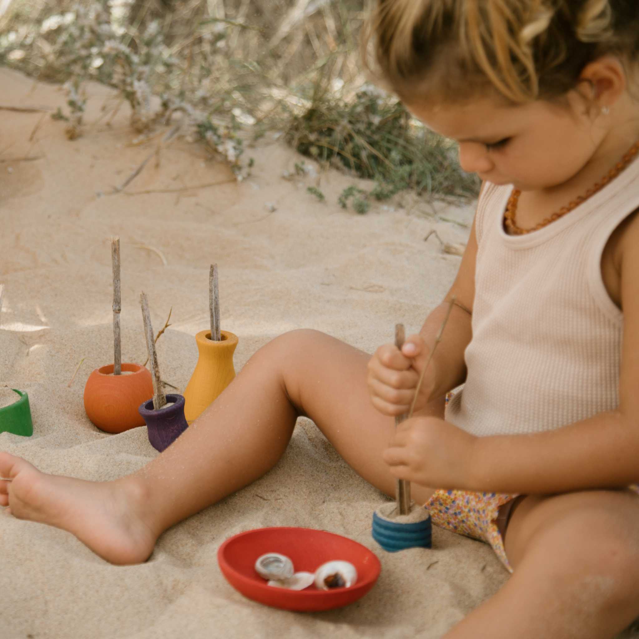 Little Girl On Beach With Grapat Pots