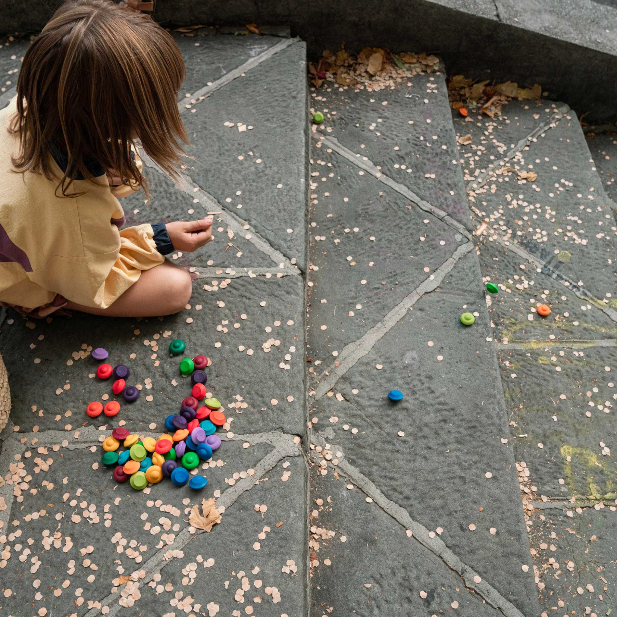 Little-Girl-On-Stone-Steps-Playing-With-Grapat-Mandala-Rainbow-Flowers
