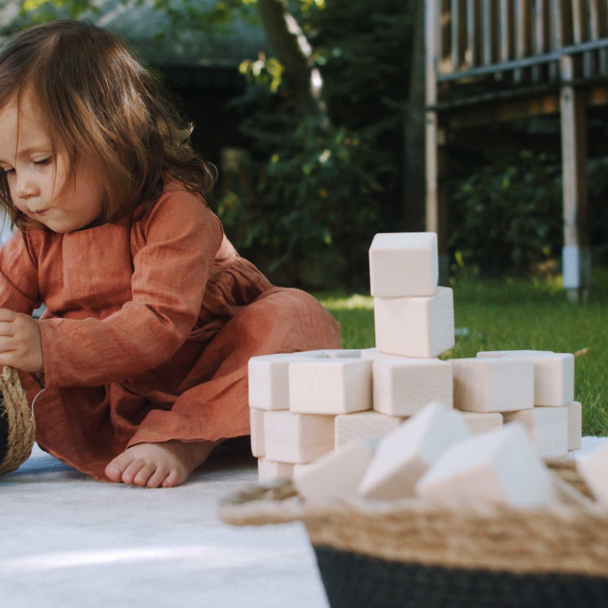 Little Girl Playing With Just Blocks Baby Set In Garden