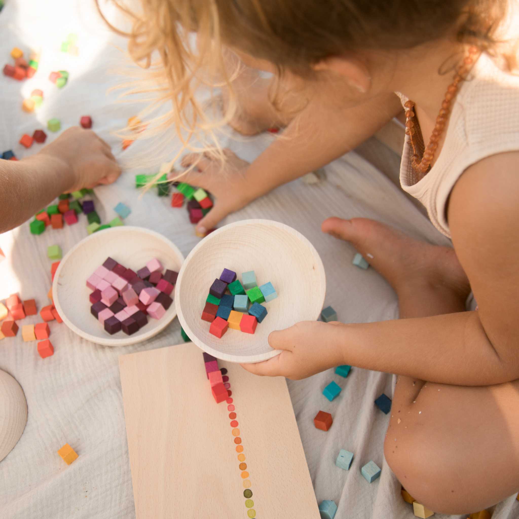 Little Girl Sorting Grapat Mis And Match Pieces Into Bowls