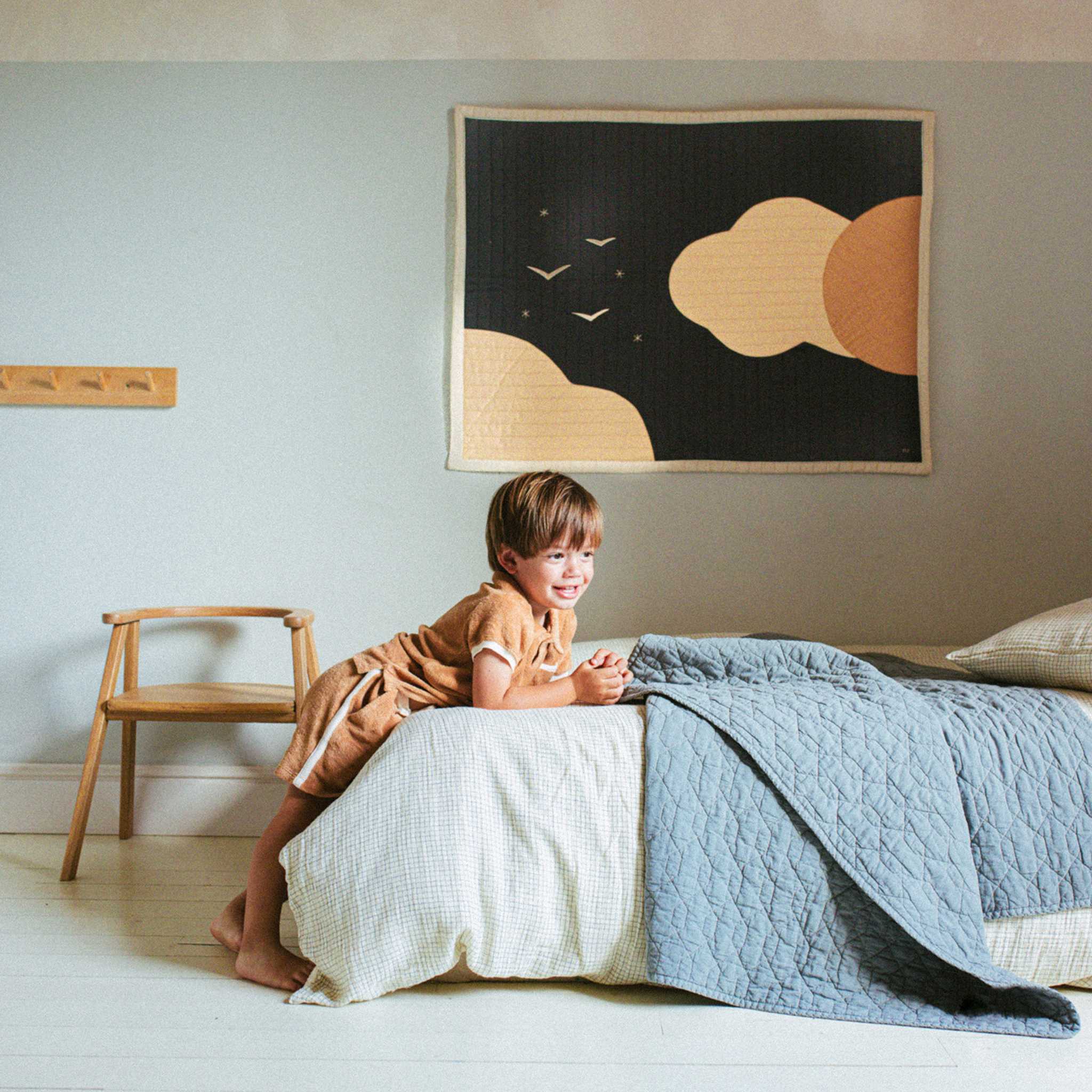 Nobodinoz Wabi Sabi Quilted Blanket - Azure - On Bed With Child