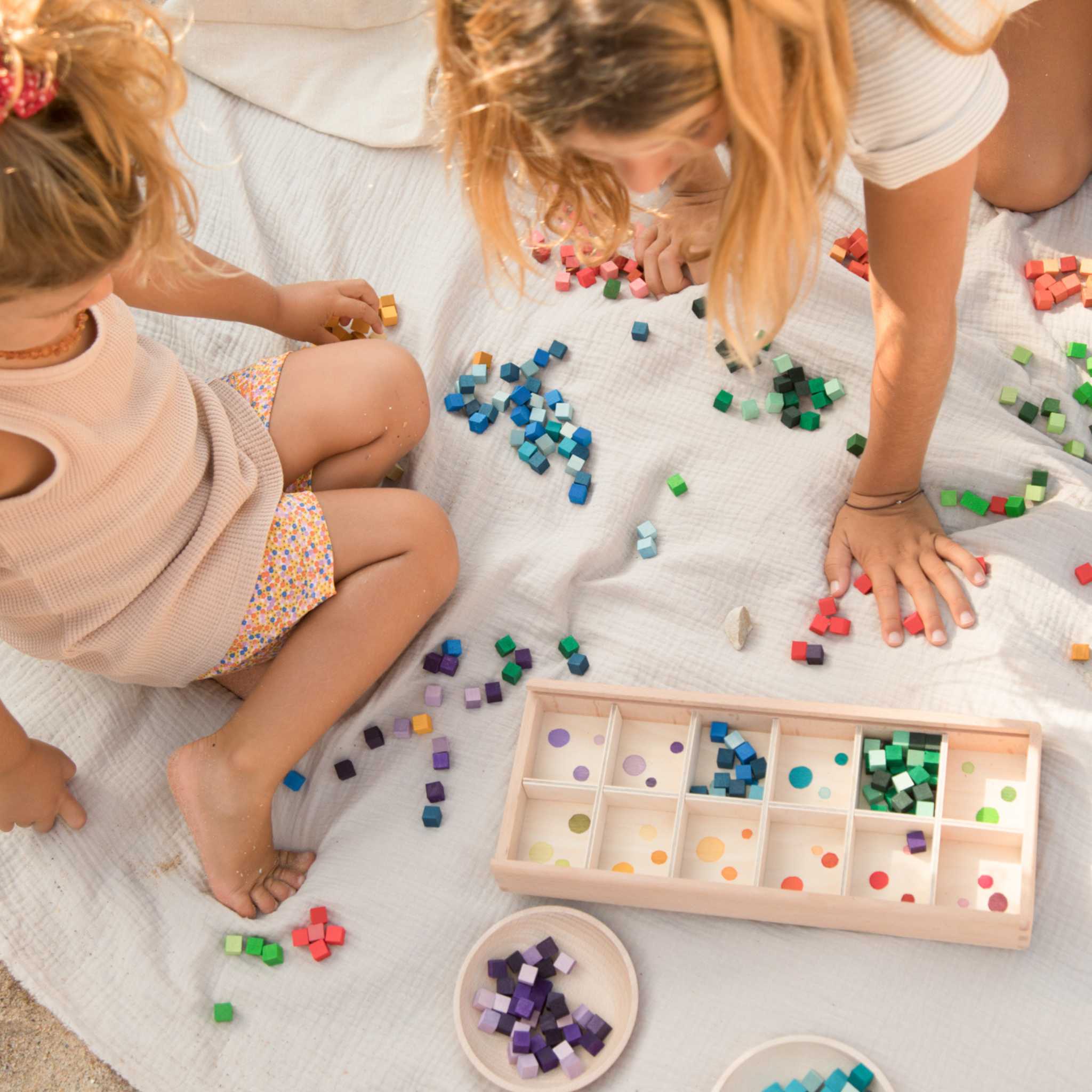 Two Children Playing With Grapat Mis And Match Laid Out On Rug