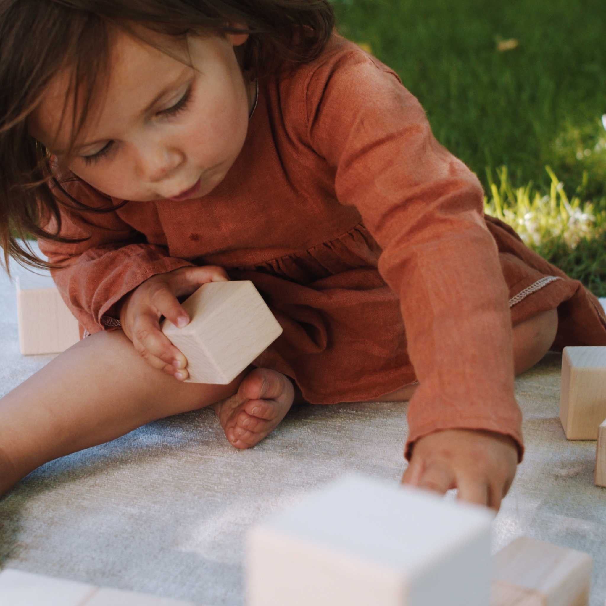 Up Close Of Little Girl Playing With Just Blocks Baby Set In Garden