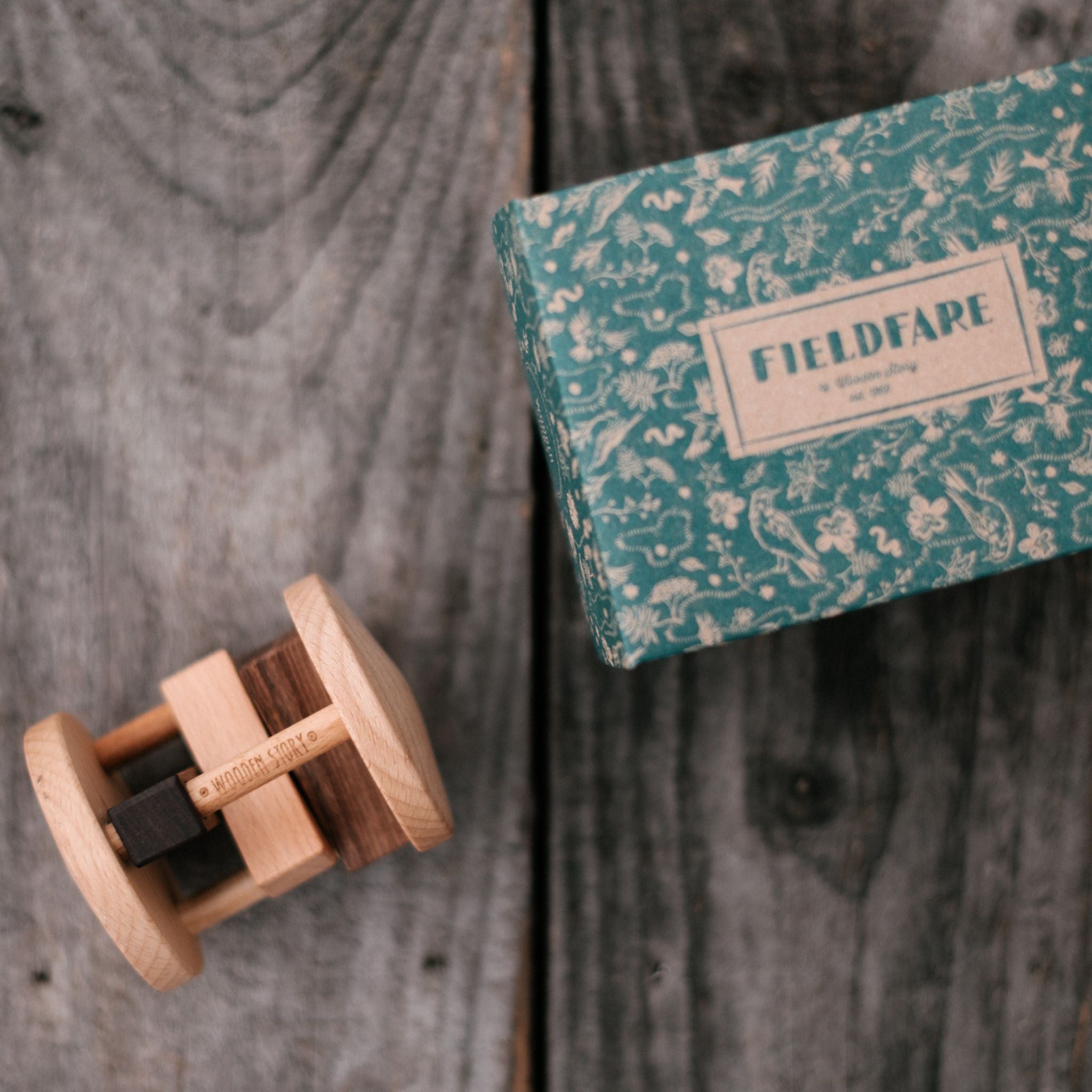 Wooden Story Fieldfare Rattle - Styled With Box On Wood