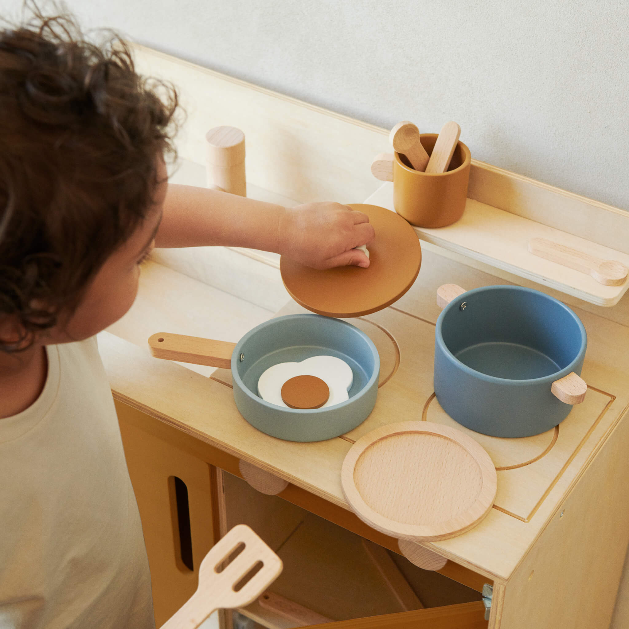 Boy Playing with Liewood Antonio Wooden Play Cooking Set in Blue Multi Mix