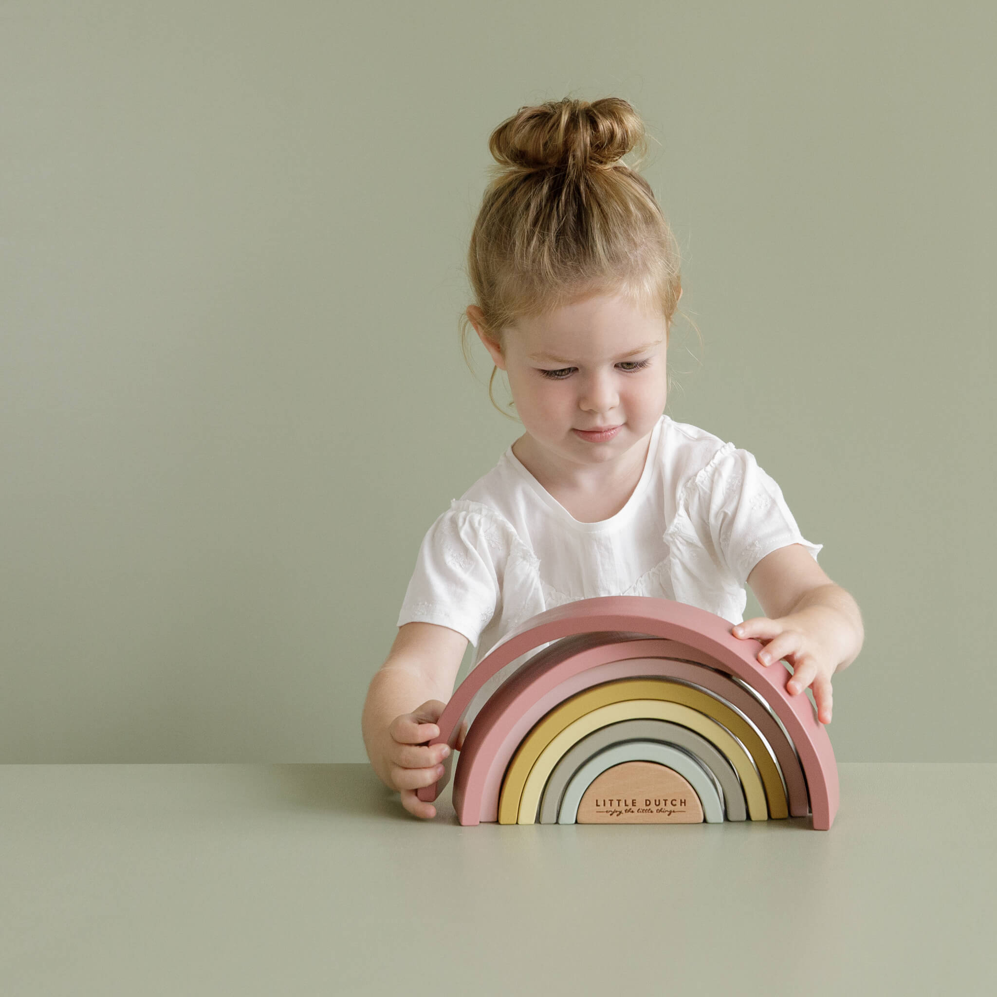 Little Dutch Girl Playing with Wooden Rainbow Stacker in Pink. Stacking Toy