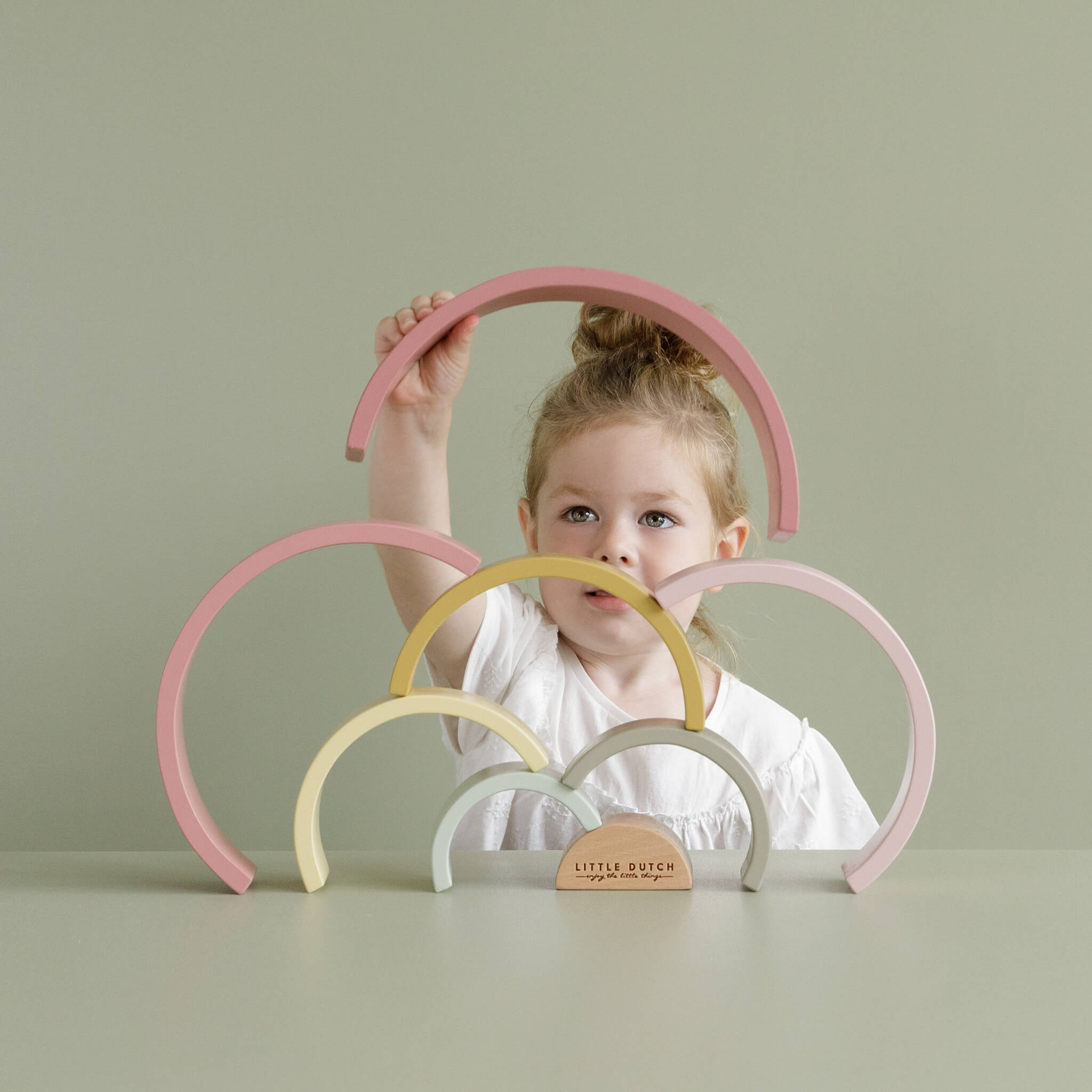 Little Dutch Girl Playing with Wooden Rainbow Stacker in Pink. Stacking Toy