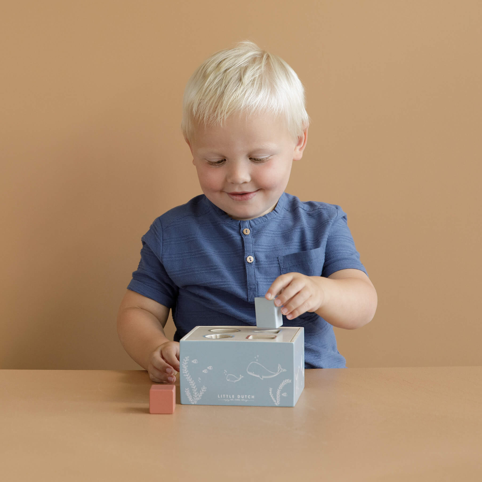 Boy Playing Little Dutch Shape Sorter in Ocean