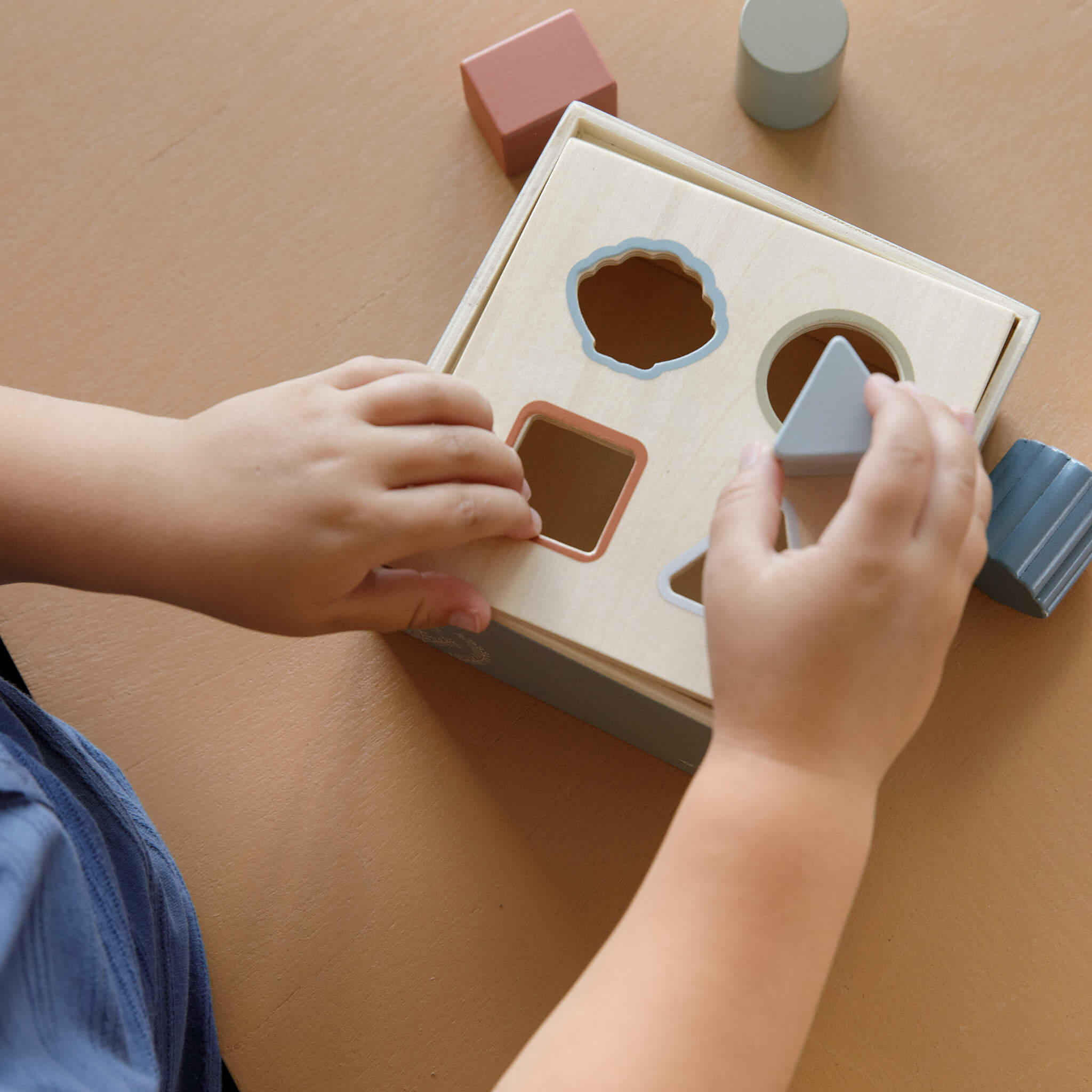 Boy using Little Dutch Shape Sorter in Ocean