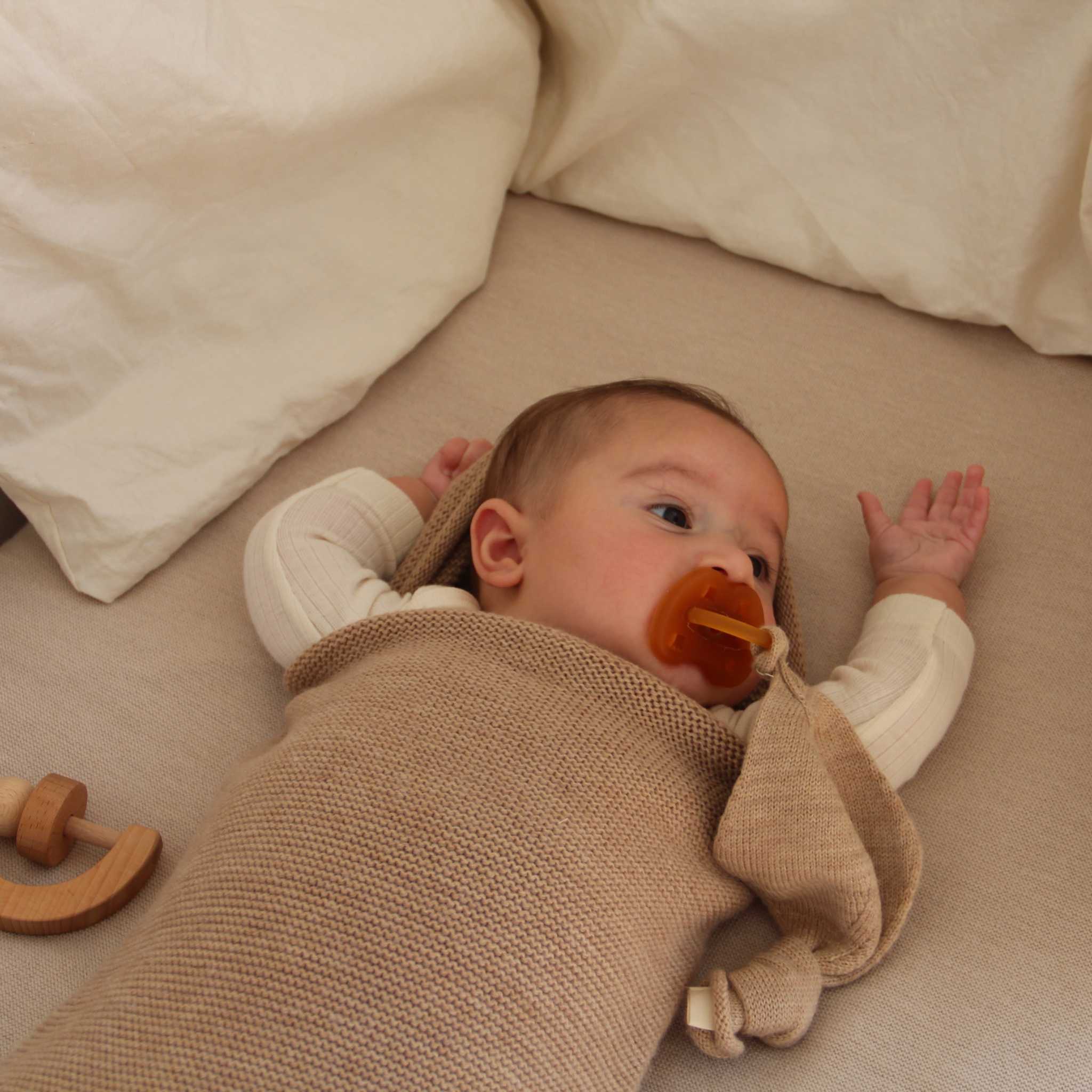 Baby In Cot In Hvid Merino Wool Cocoon In Sand 