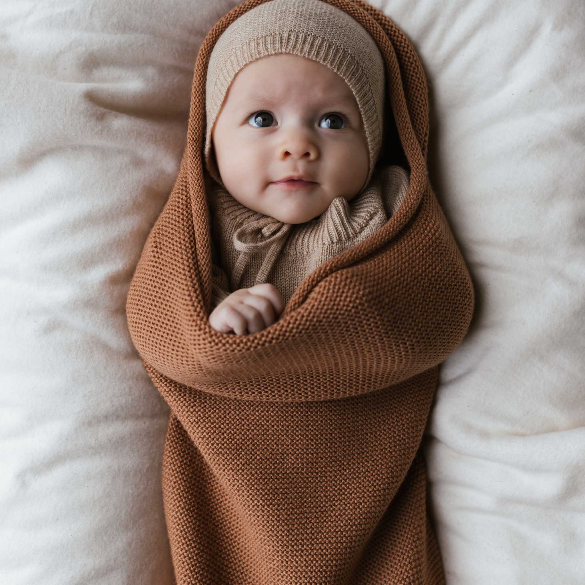 Baby Wrapped in Hvid Merino Wool Cocoon In Terracotta