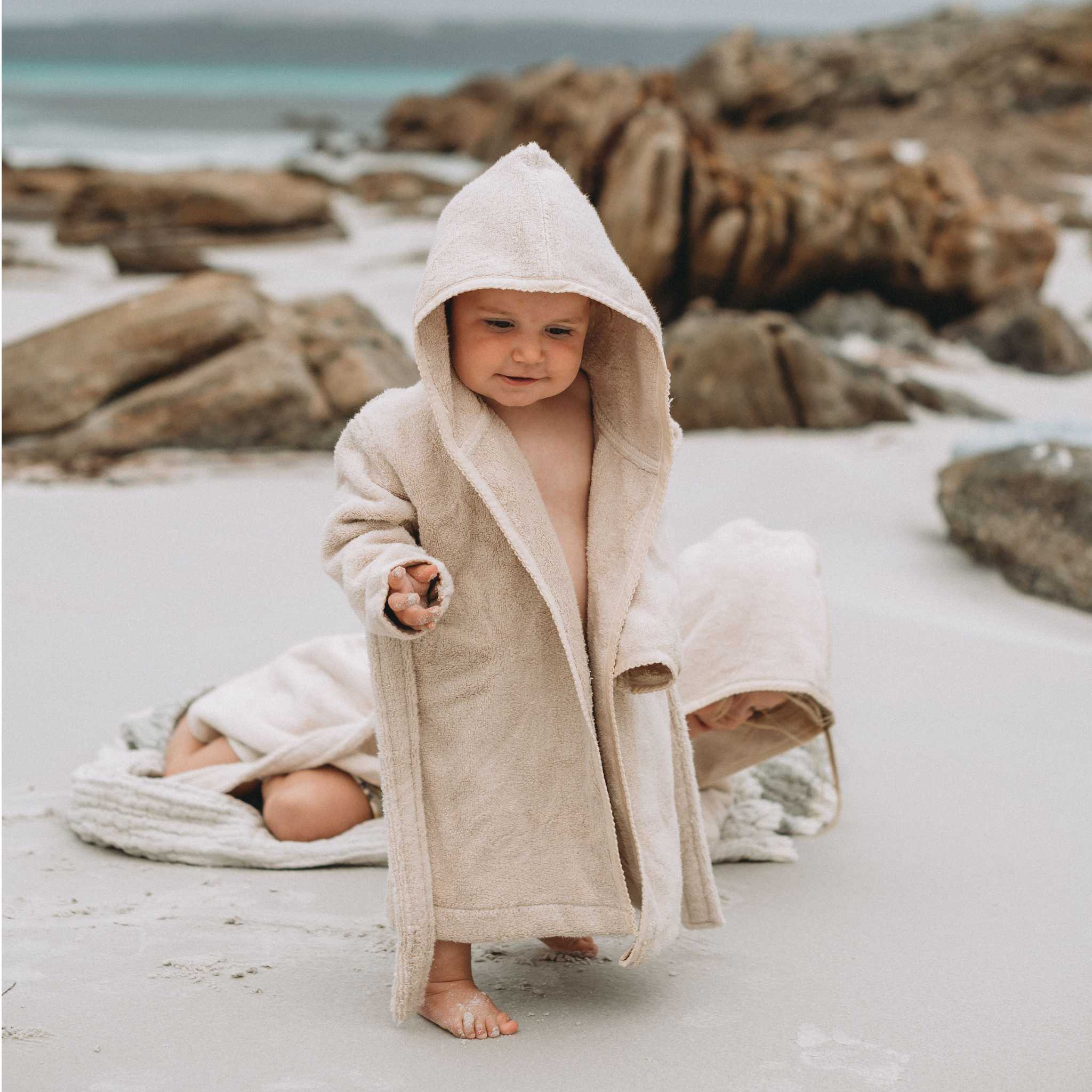 Child Playing In Garbo & Friends Bathrobe Sand On Beach