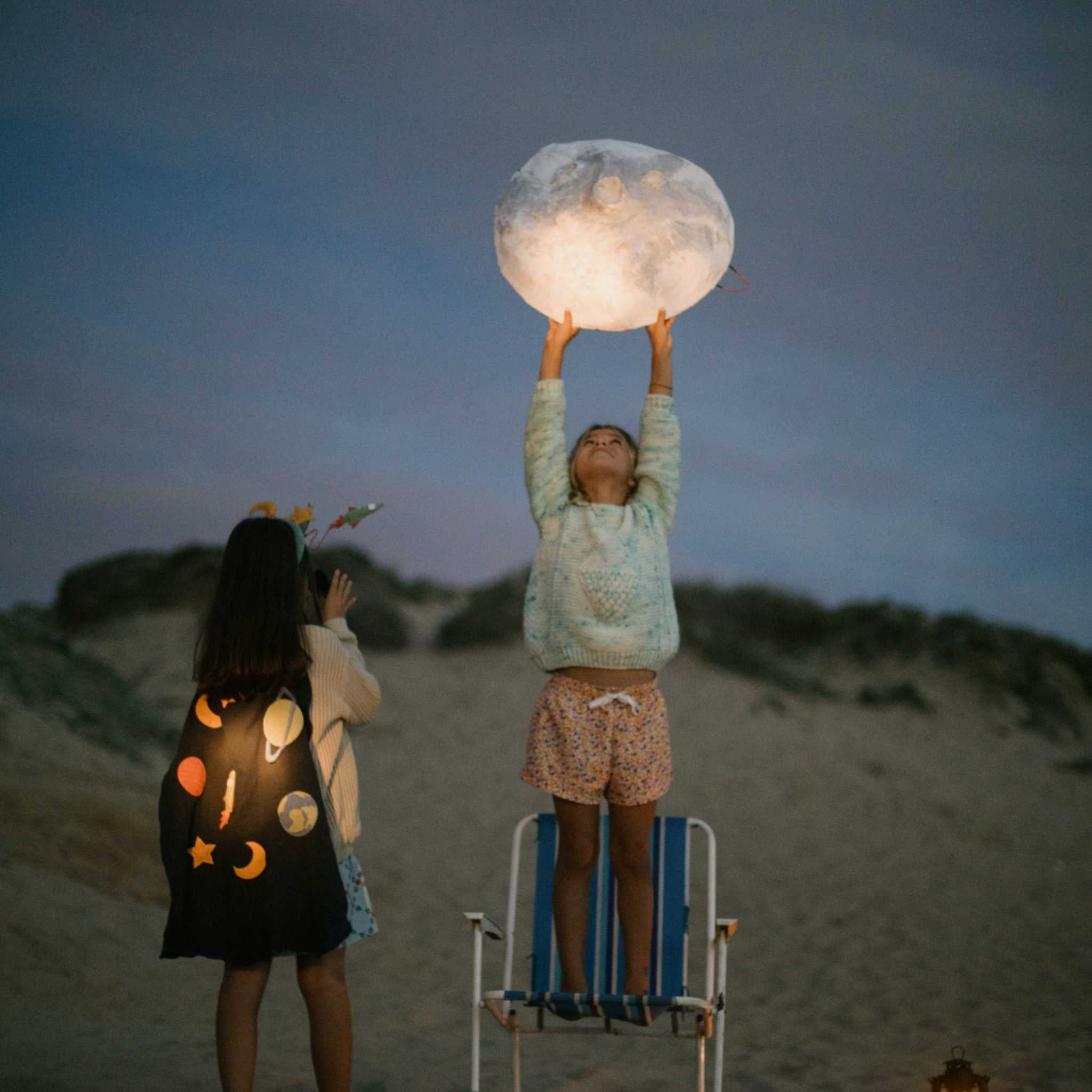 Children On Beach Holding Large Lantern