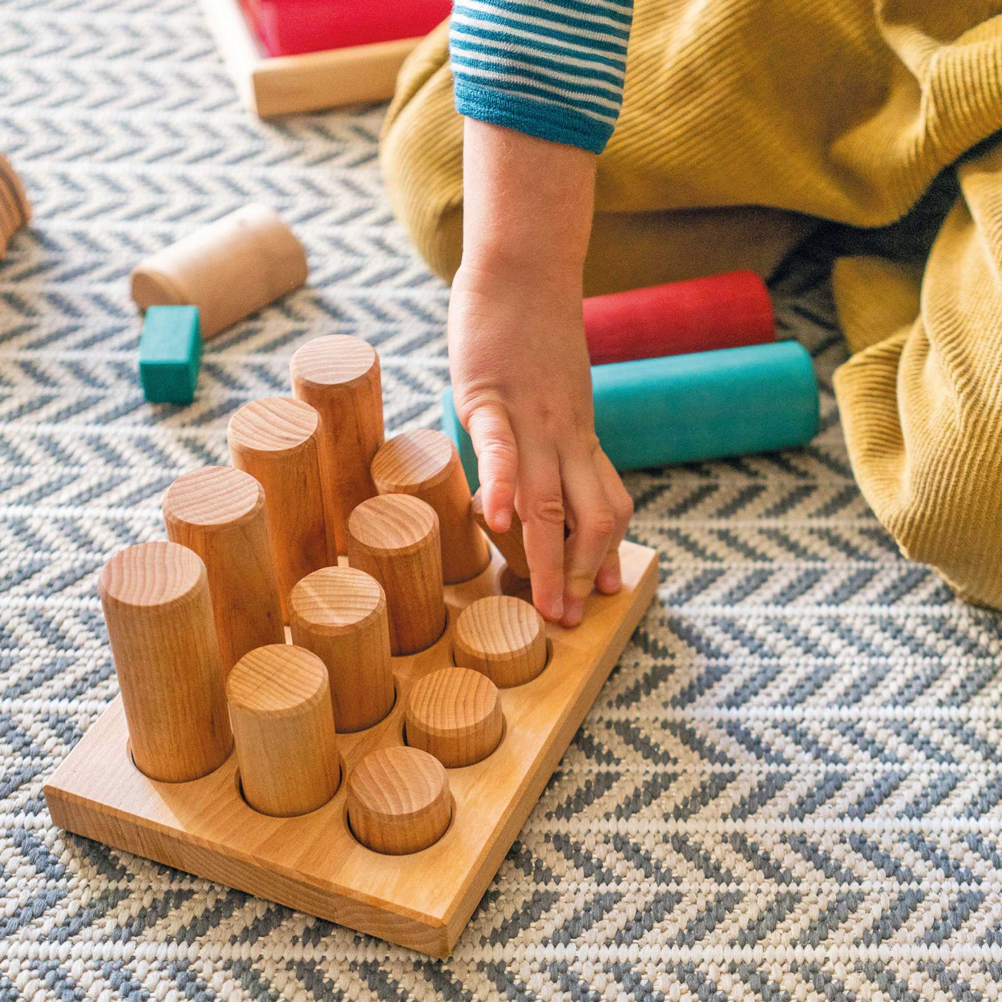 Child Playing with Grimm's Stacking Game Small Natural Rollers