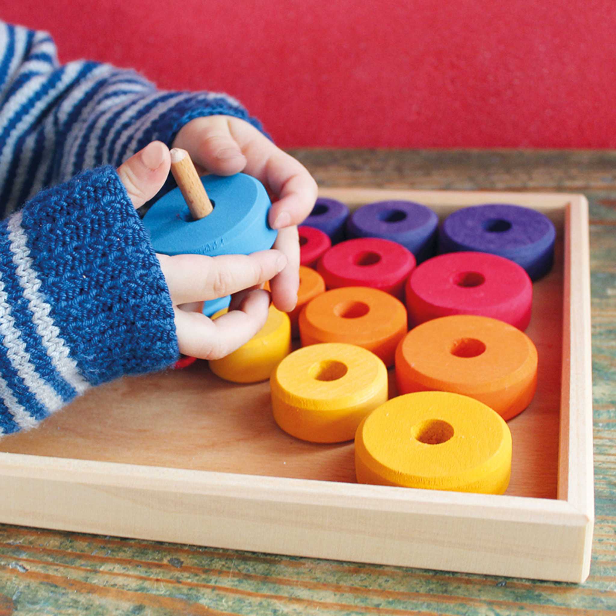 Child Playing With Grimm's Rainbow First Thread Game