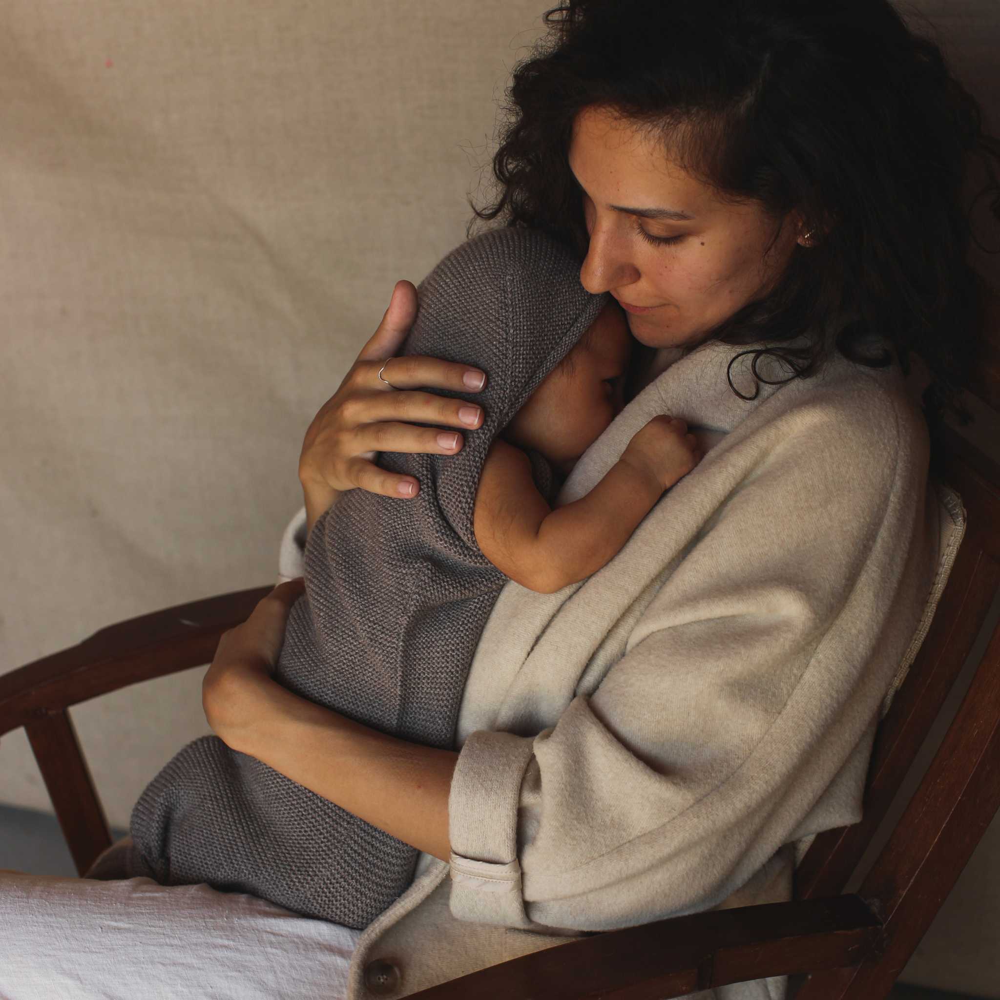 Lady Holding Baby In Hvid Merino Wool Cocoon In Otter