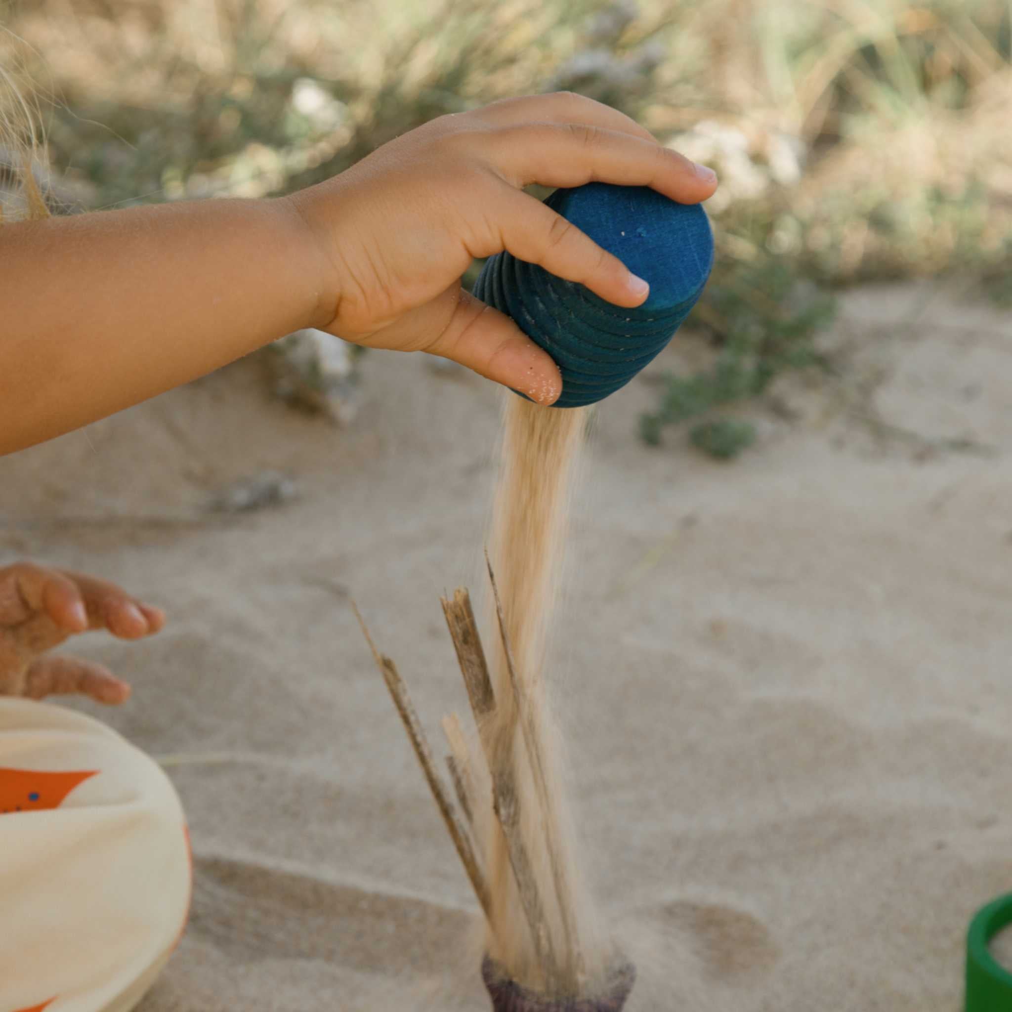 Little Hand Tipping Sand From Grapat Blue Pot