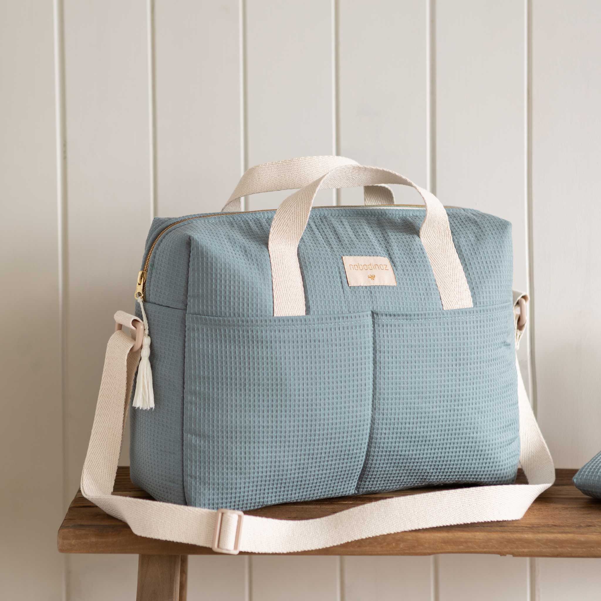 Nobodinoz Gala Changing Bag - Stone Blue - Styled Image on Bench 