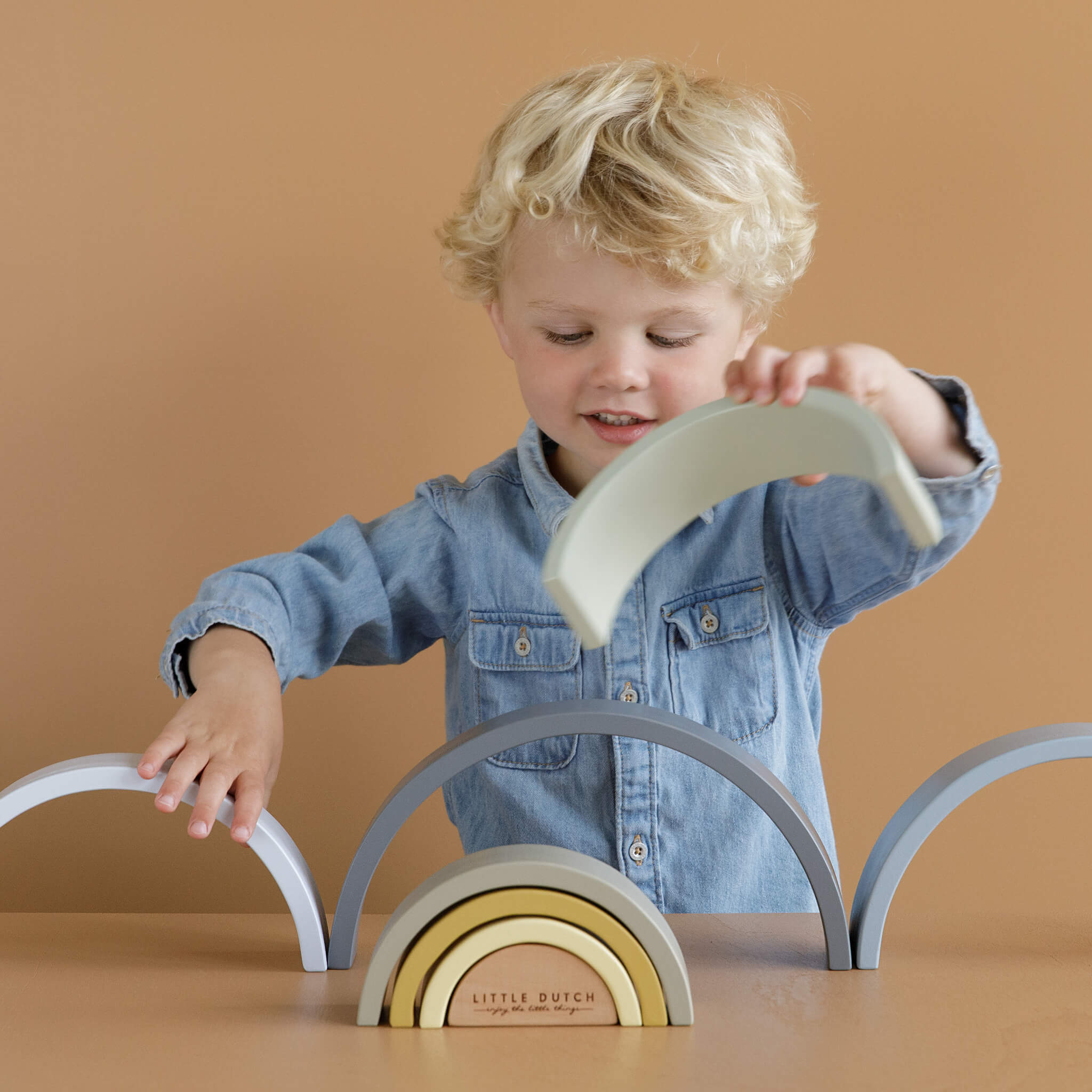 Boy Playing with Little Dutch Wooden Rainbow Stacker in Blue. Stacking Toy 