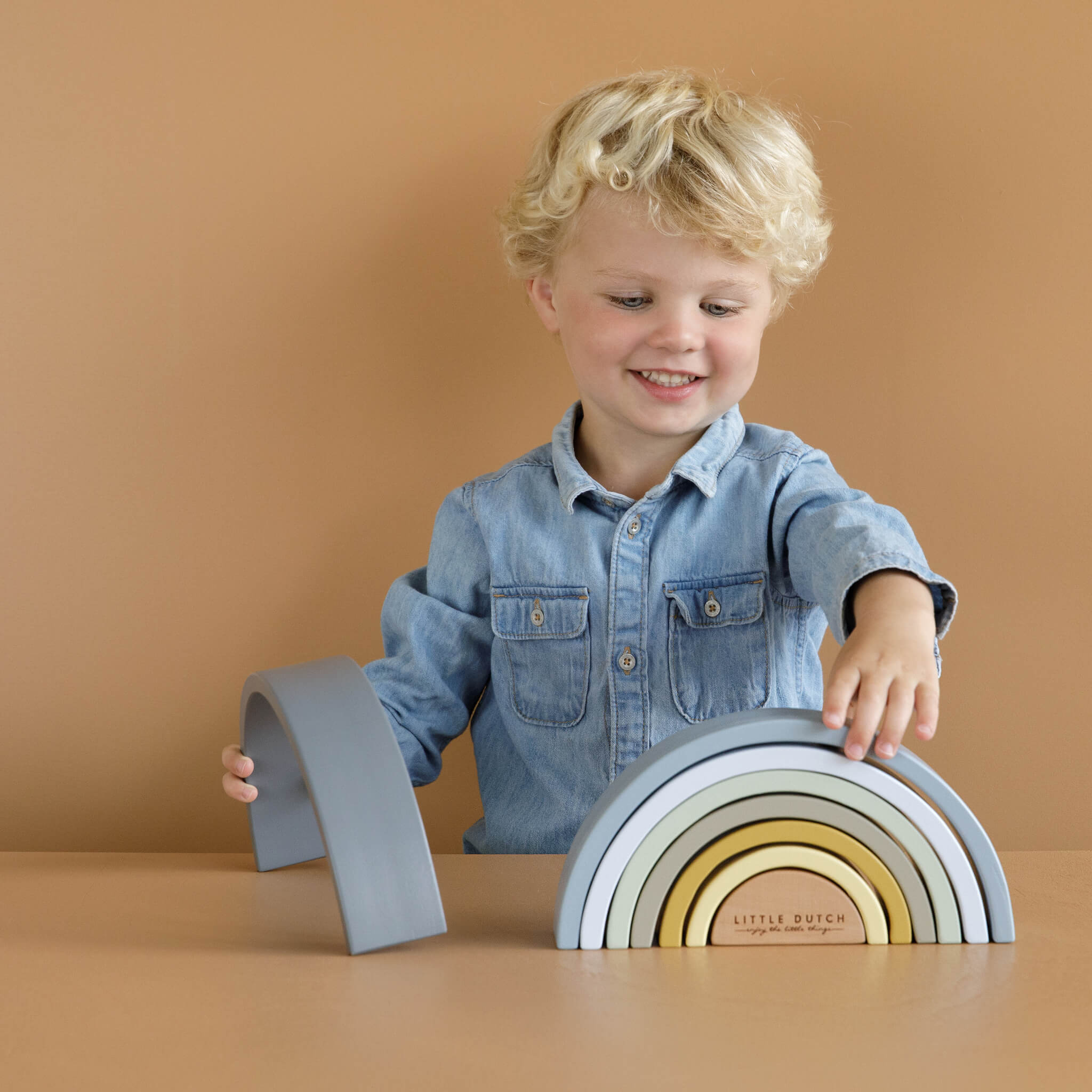 Boy Playing with Little Dutch Wooden Rainbow Stacker in Blue. Stacking Toy