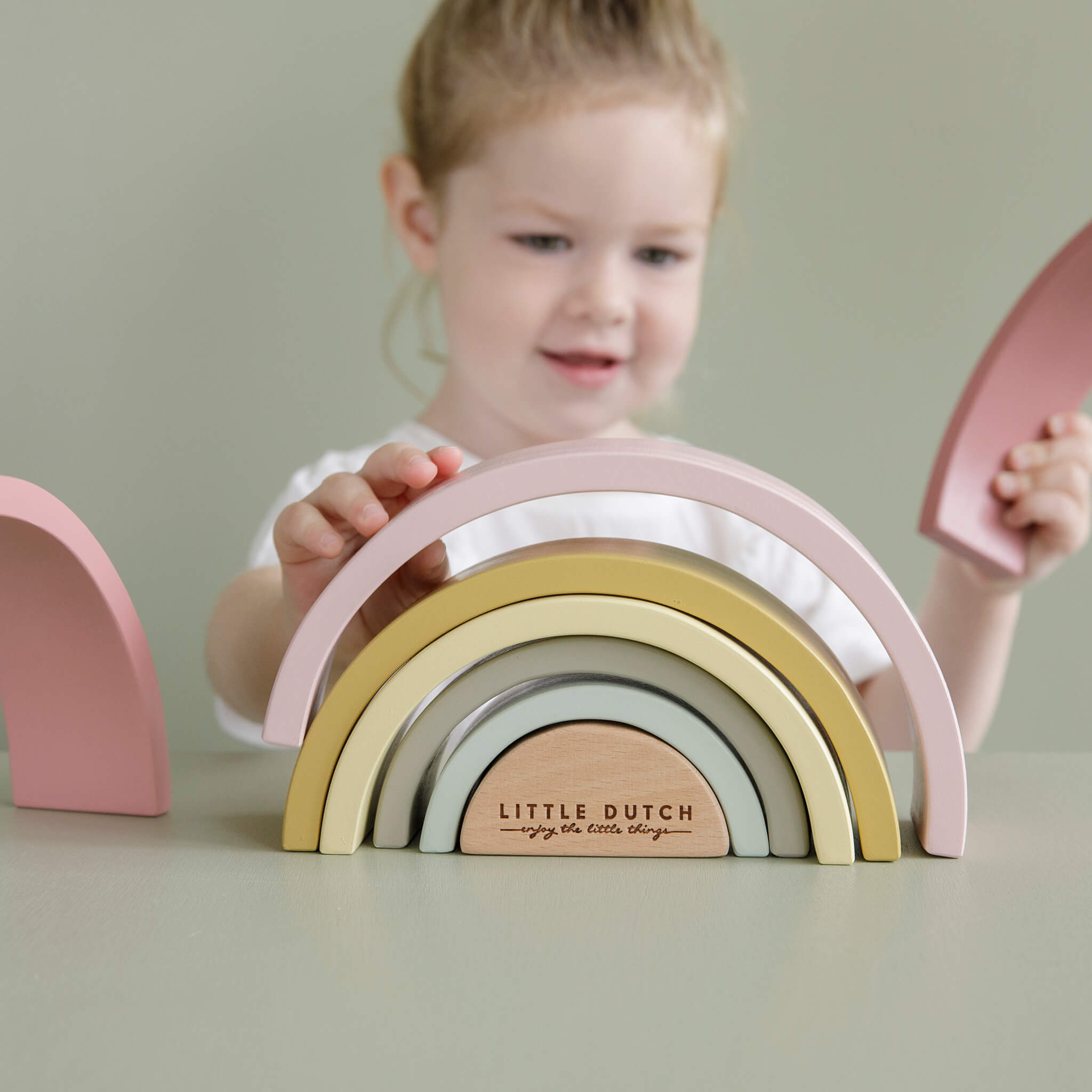 Girl Playing Little Dutch Wooden Rainbow Stacker in Pink. Stacking Toy