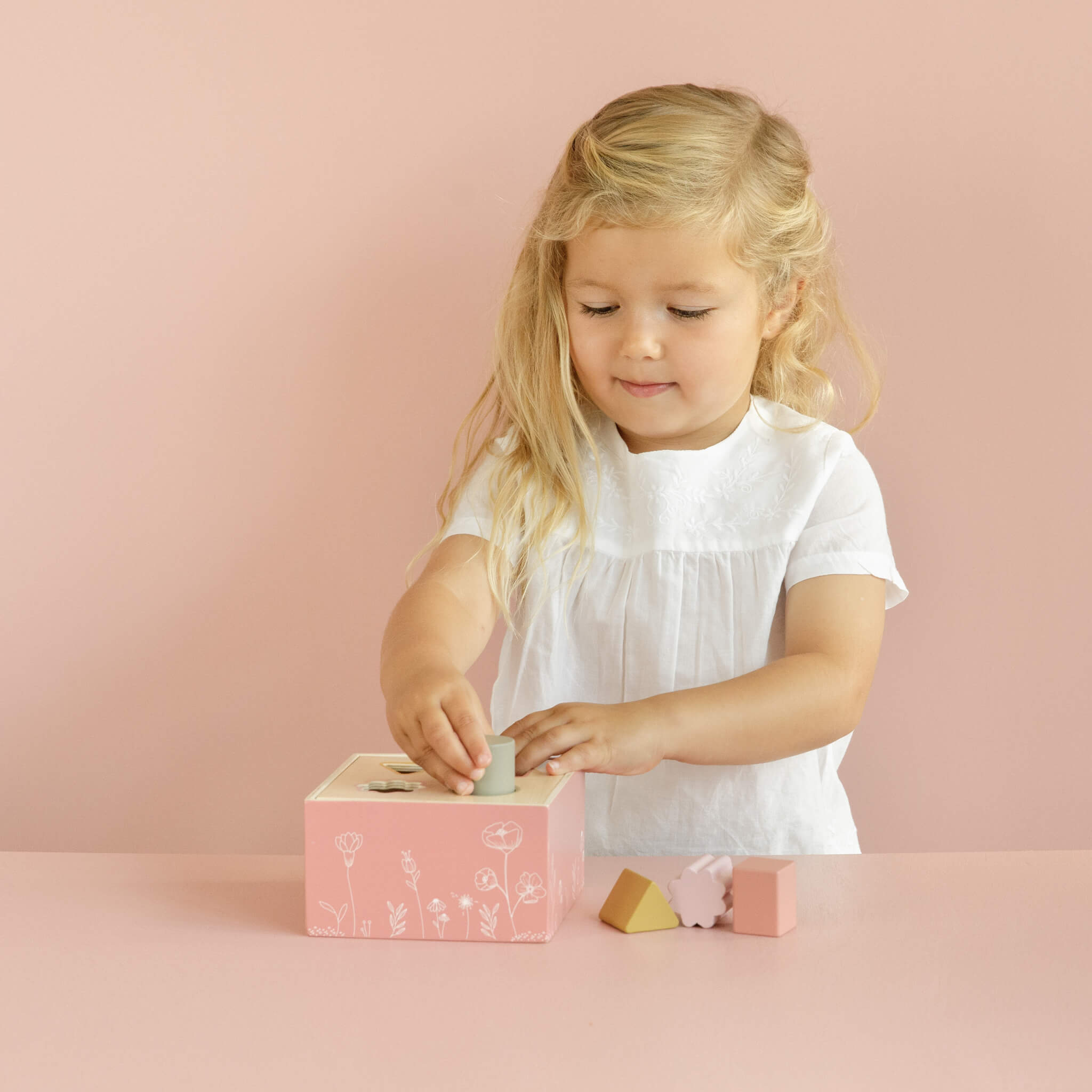 Child Playing with Little Dutch Shape Sorter in Flowers