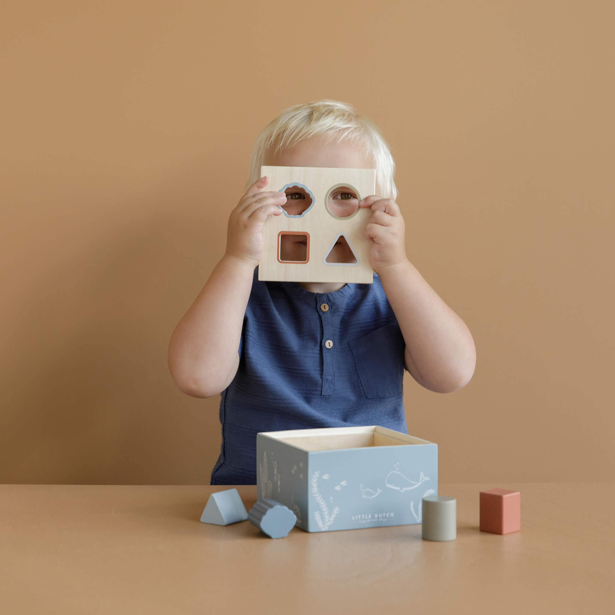 Boy Playing Little Dutch Shape Sorter in Ocean